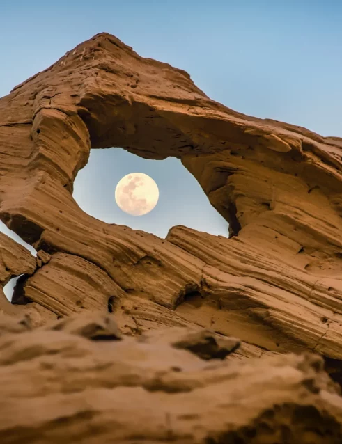 Der Mond, gesehen durch eine Lücke in einer der fossilen Dünen von Al Wathba.