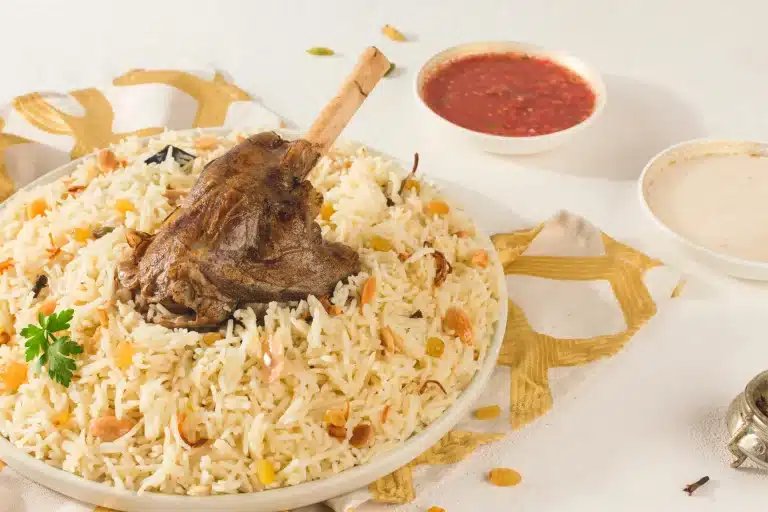 Langsam gegartes Lammfleisch auf duftendem Reis, ein klassisches Beispiel für die reichhaltigen kulinarischen Traditionen Abu Dhabis.