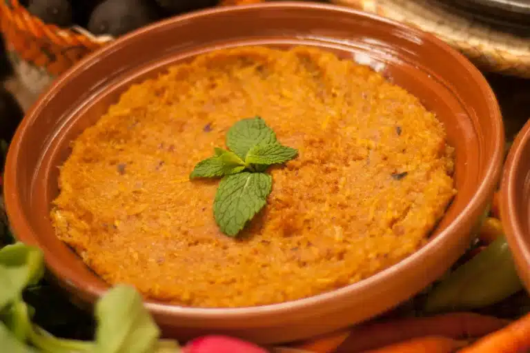 Traditionelles herzhaftes Gericht, serviert in einer Tonschale, das die authentische Küche Abu Dhabis hervorhebt.