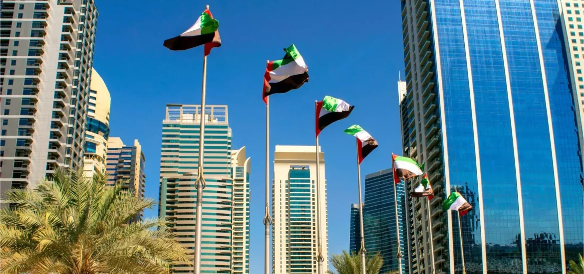 UAE flags waving between modern skyscrapers in Abu Dhabi during celebration of UAE National Day in Abu Dhabi.