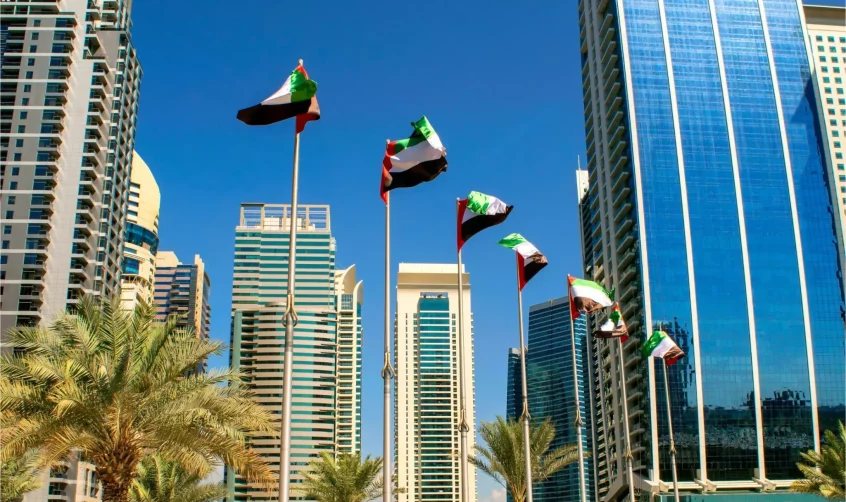 Fahnen der Vereinigten Arabischen Emirate wehen zwischen modernen Wolkenkratzern in Abu Dhabi während der Feierlichkeiten zum Nationalfeiertag der Vereinigten Arabischen Emirate in Abu Dhabi.