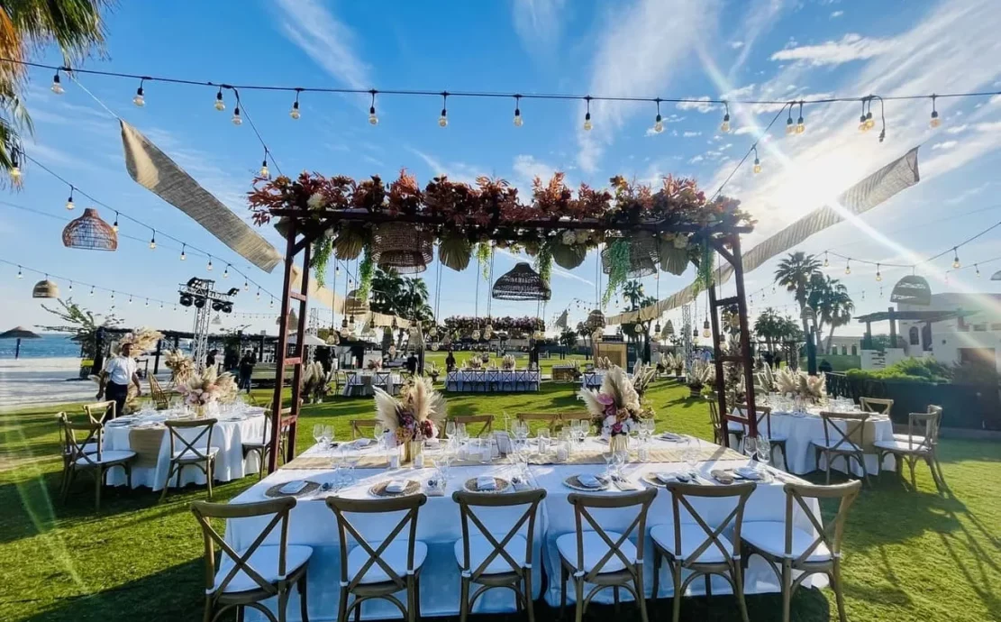 Garden wedding reception at Al Maya beach resort in Abu Dhabi with floral pergola