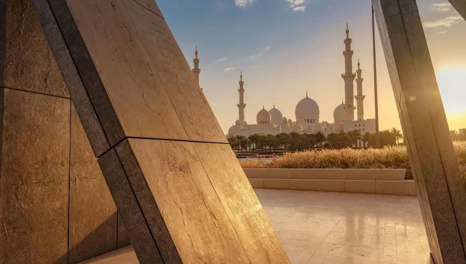 Das Wahat Al Karama-Denkmal bei Sonnenuntergang mit der Scheich-Zayed-Moschee im Hintergrund