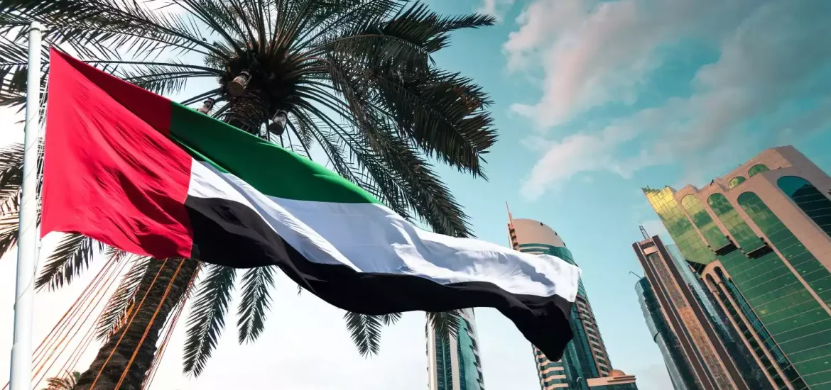 Die Nationalflagge der Vereinigten Arabischen Emirate weht neben Palmen und modernen Wolkenkratzern in Abu Dhabi und symbolisiert die Feierlichkeiten zum Scheich-Zayed-Festival.