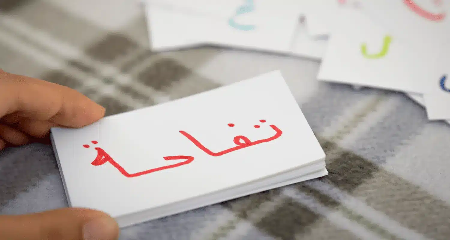 A board with the word "apple" written in Arabic.