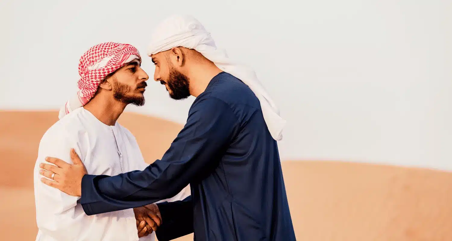 Two people performing a traditional Arabic greeting.