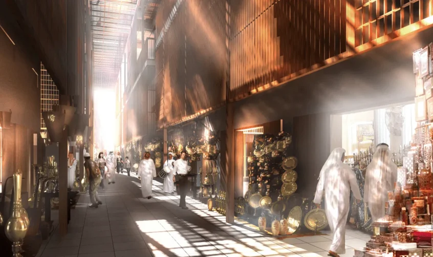 Traditioneller emiratischer Souk in Abu Dhabi mit sonnendurchfluteten Gängen und Marktständen, an denen Messingwaren und handwerkliche Erzeugnisse angeboten werden.