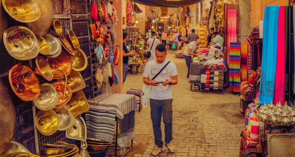 Traditioneller Souk-Markt in Abu Dhabi mit bunten Textilien, Messingwaren und lokalem Kunsthandwerk zum Verkauf.