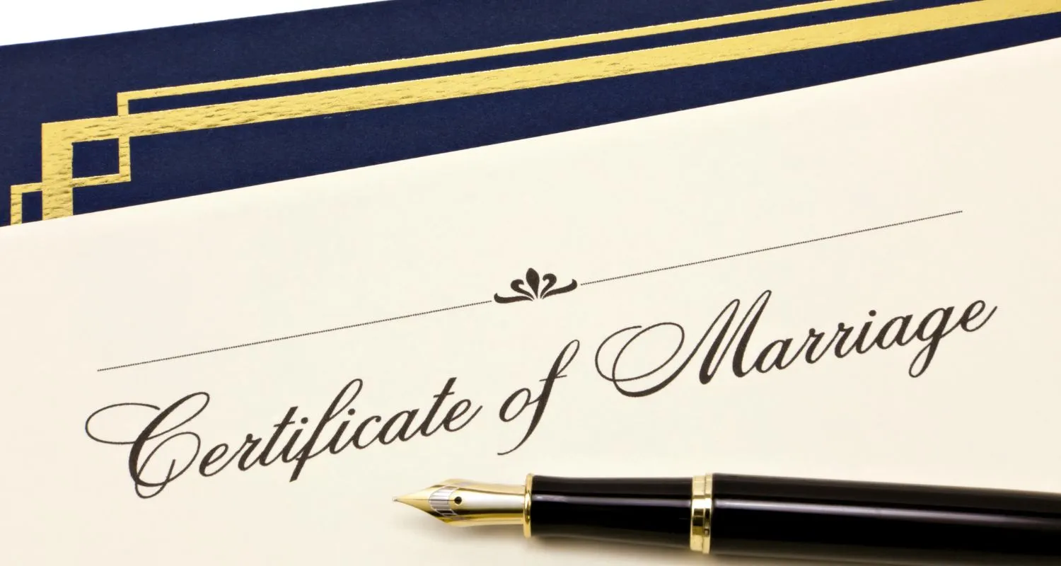 Elegant certificate of marriage with a black and gold fountain pen, symbolizing the official union of two people
