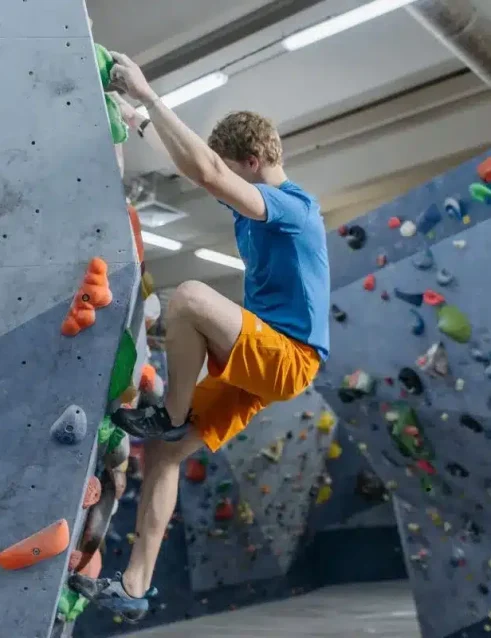 Mann beim Indoor-Klettern, einer der aufregenden Indoor-Aktivitäten in Abu Dhabi.