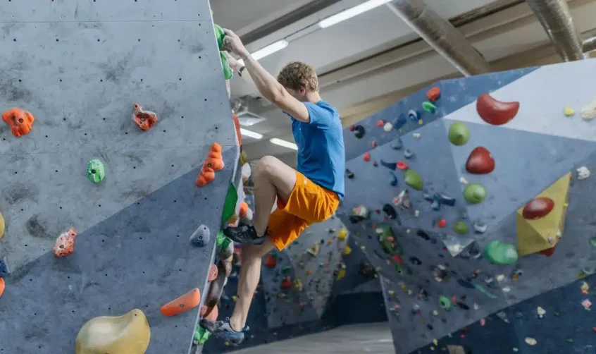 Mann beim Indoor-Klettern, einer der aufregenden Indoor-Aktivitäten in Abu Dhabi.