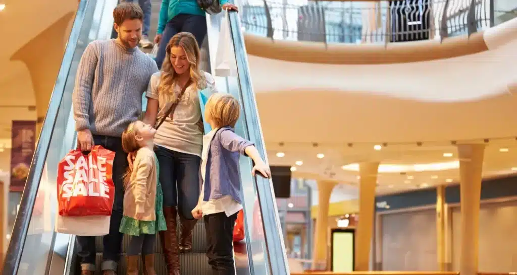 Happy family shopping in a modern mall, highlighting shopping as one of the best indoor activities in Abu Dhabi.