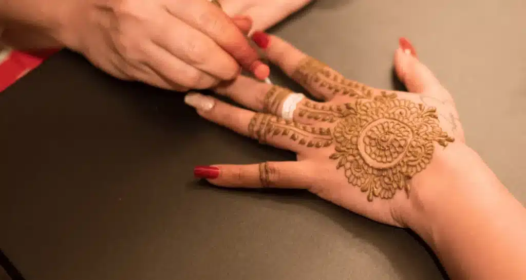 Henna-Tattoo wird auf eine Hand aufgetragen.