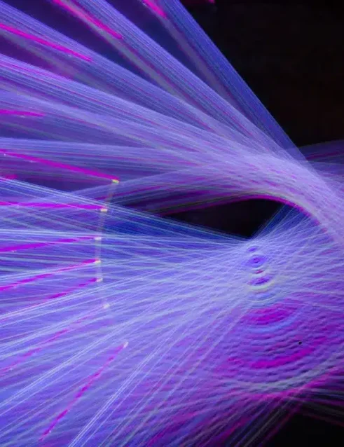 Lichtinstallation beim Manar Abu Dhabi Festival mit leuchtenden violetten und blauen Lichtstrahlen