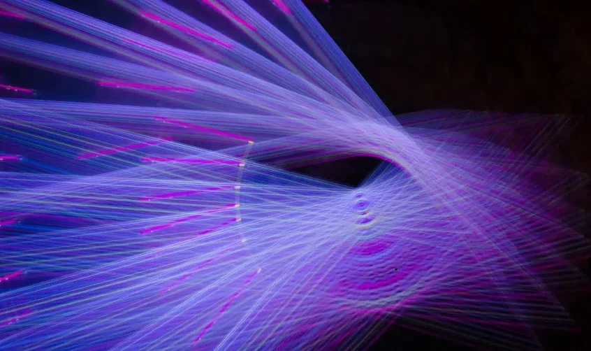 Lichtinstallation beim Manar Abu Dhabi Festival mit leuchtenden violetten und blauen Lichtstrahlen