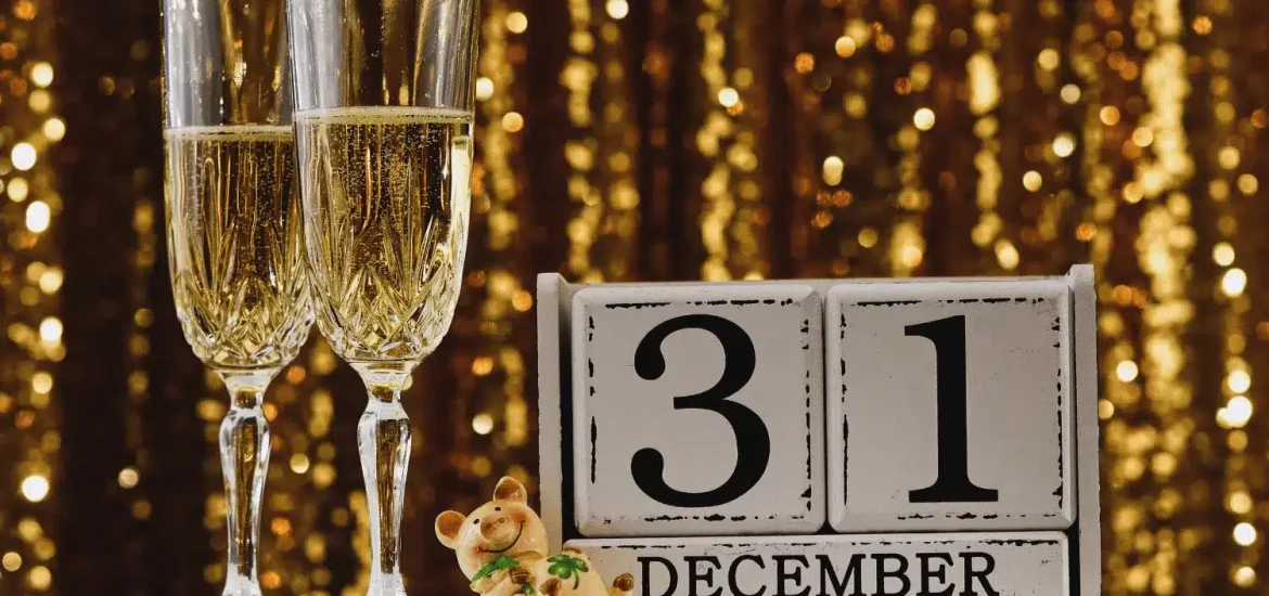 Zwei Gläser Champagner neben einem Kalender mit dem Datum 31. Dezember.