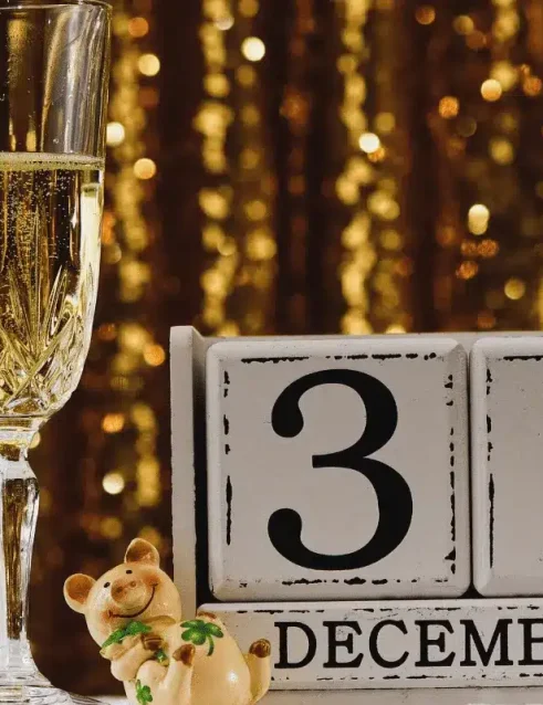 Zwei Gläser Champagner neben einem Kalender mit dem Datum 31. Dezember.