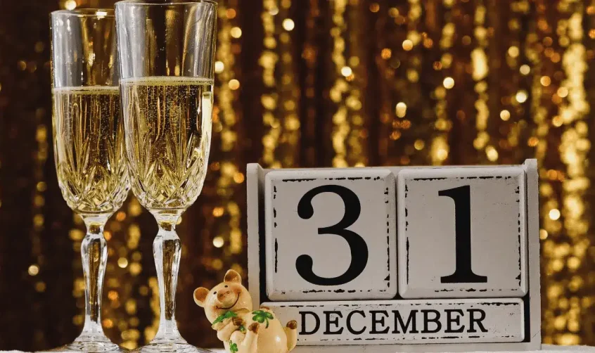 Zwei Gläser Champagner neben einem Kalender mit dem Datum 31. Dezember.