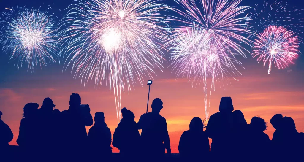 Silhouetten von Menschen, die in Abu Dhabi ein Feuerwerk beobachten.