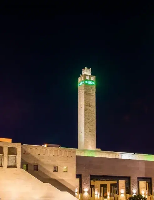 Die Scheicha-Salama-Moschee in Al Ain, die nachts mit ihren hohen Minaretten und ihrer traditionellen islamischen Architektur beleuchtet ist.