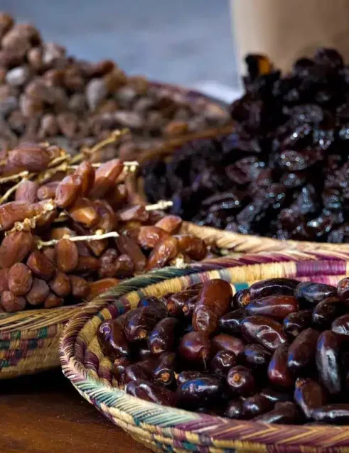 Körbe mit frischen und getrockneten Datteln auf dem Dattelmarkt in Abu Dhabi