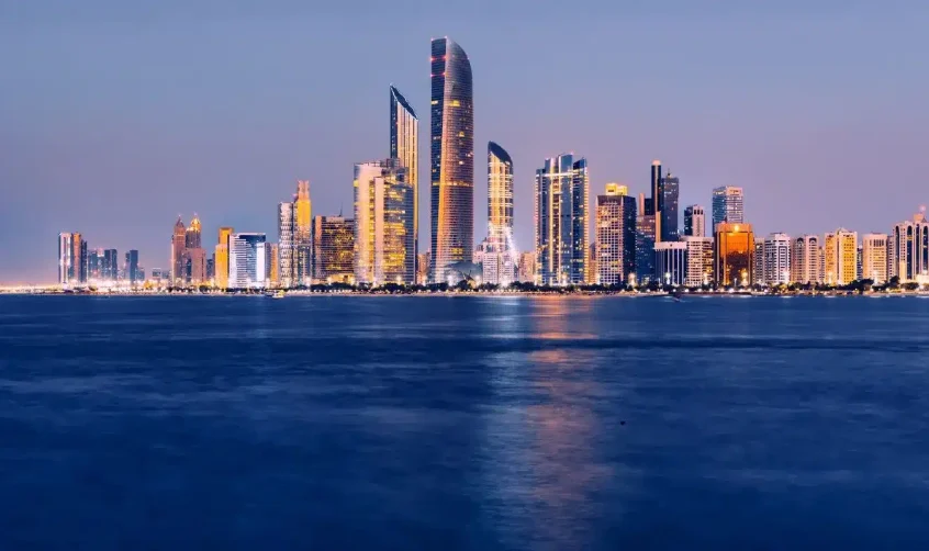 Blick auf die Skyline von Abu Dhabi in der Nähe des Kulturviertels Manarat Al Saadiyat in der Abenddämmerung