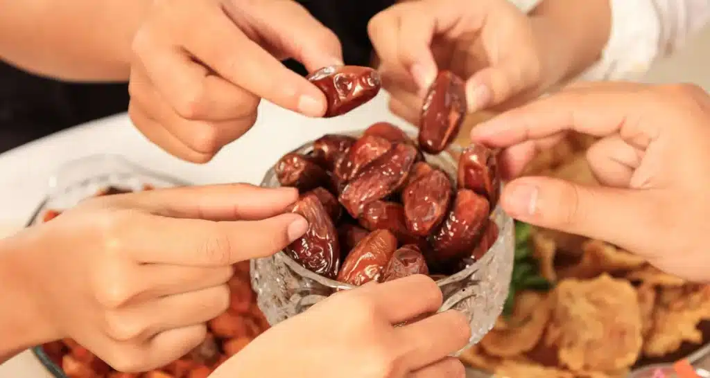 Menschen, die frische Datteln auf dem Dattelmarkt von Abu Dhabi teilen