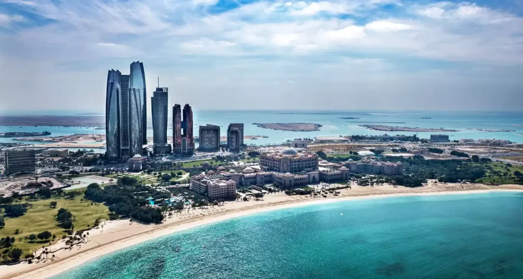 Luftaufnahme des Abu Dhabi Beach mit der Skyline der Stadt und der türkisfarbenen Küste des Arabischen Golfs.
