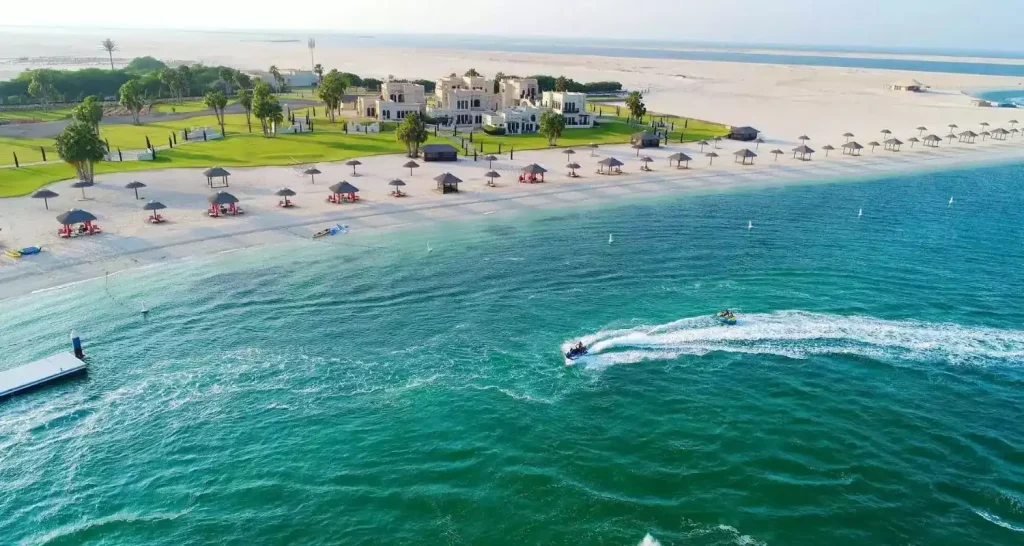 Luftaufnahme des Al Maya Island Resort mit Sonnenschirmen und türkisfarbenem Meer in der Nähe von Abu Dhabi.