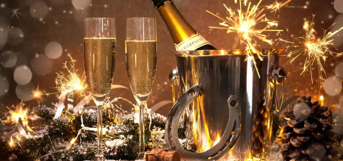 Champagnerflasche in einem Eiskübel mit Wunderkerzen und festlicher Dekoration, symbolisch für das neue Jahr in Abu Dhabi.