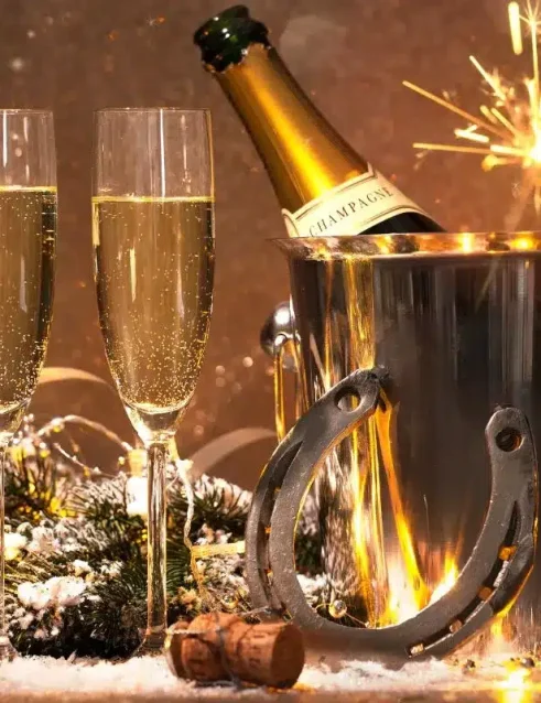 Champagnerflasche in einem Eiskübel mit Wunderkerzen und festlicher Dekoration, symbolisch für das neue Jahr in Abu Dhabi.