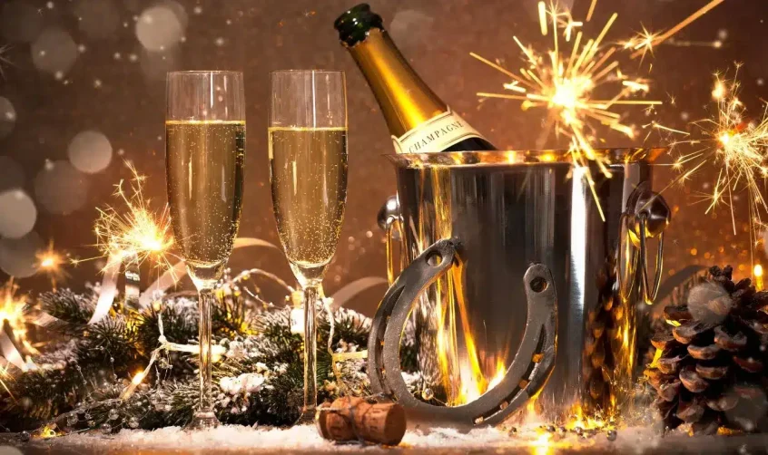 Champagnerflasche in einem Eiskübel mit Wunderkerzen und festlicher Dekoration, symbolisch für das neue Jahr in Abu Dhabi.