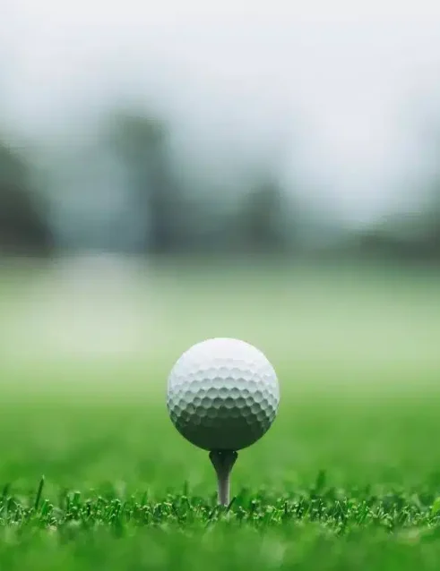 Golfball auf dem Tee, bereit für den ersten Schlag im Abu Dhabi City Golf Club.