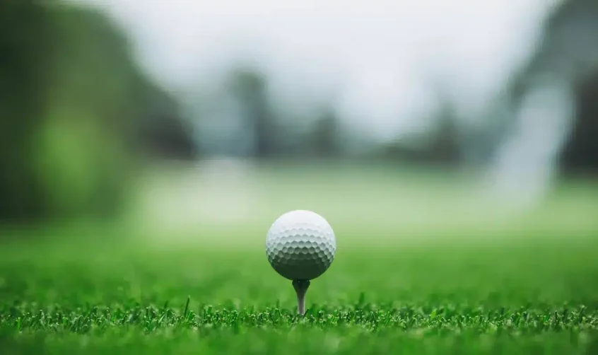 Golfball auf dem Tee, bereit für den ersten Schlag im Abu Dhabi City Golf Club.