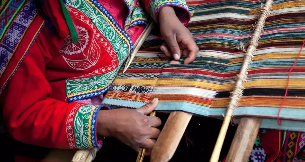 Handwerker weben farbenfrohe Sadu-Textilien im Handwerksbereich des Sheikh Zayed Festivals 2025.