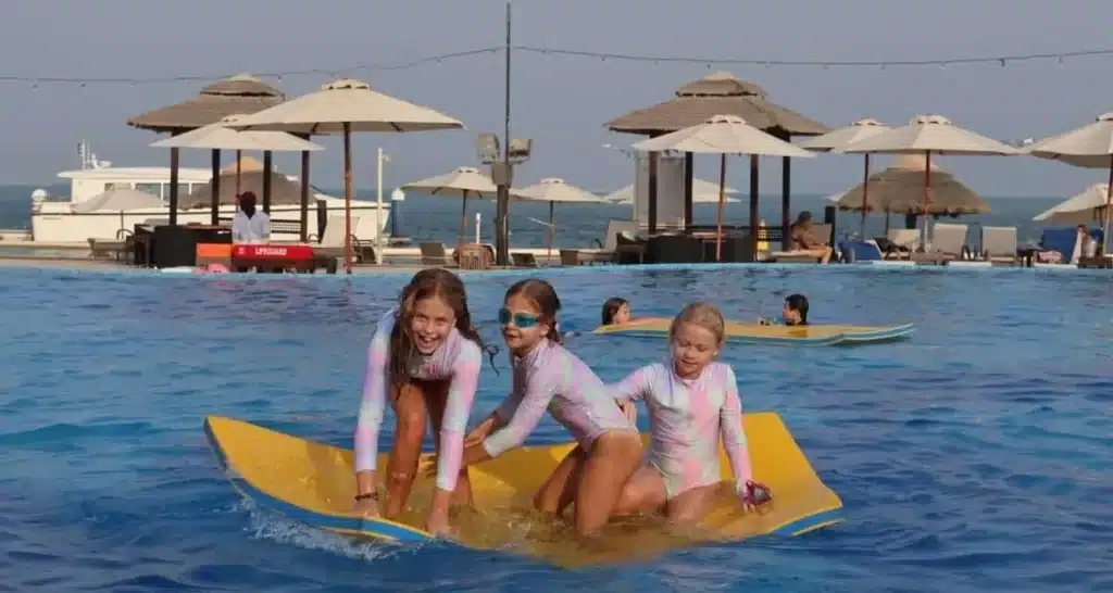 Kinder spielen auf schwimmenden Matten im Pool von Al Maya Island.
